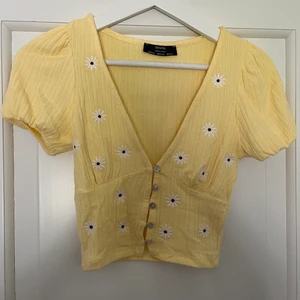 Topp med blommor storlek xs - Supersöt gul topp med blommor. Passformen är helt fantastisk. Helt oanvänd!