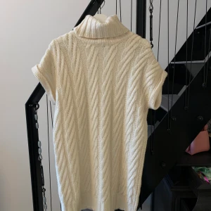 Stickad klänning från M-KAE - Väldigt fin, vit stickad klänning med rymlig polokrage. Från märket M-KAE. Har använts 2 gånger. Nyskick. Köpt för 1100kr 