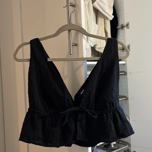 Bikbok topp storlek S  - En svart topp som man kan justera urringningen på ju hårdare man drar i snöret. Använt den en gång därför finns det ingen prislapp kvar!