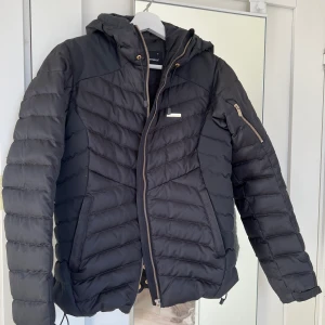 Peak performance jacka - Säljer denna super snygga skidjacka från peak performance. Jacka har snygga gulddetaljer och fungerar bäst som skidjacka. Jackan är knappt använd och därför säljer jag den för 1500kr då nypriset var 3000kr.