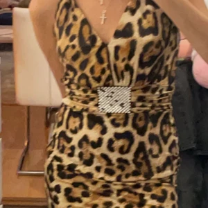 Klänning - Kort klänning med leopard print! Dock har många stenar lossnat :/ 