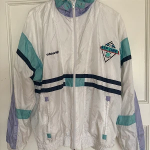 Adidas tracksuit jacka  - En vintage Adidas tracksuit pastelldröm! Har några små fläckar men i övrigt väldigt gott begagnat skick. Inte storleksmärkt men passar mig (S) till L beroende på hur oversize man vill ha den. Köparen står för spårbar frakt för 66 kr!💜