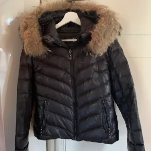Hollies jacka stl 40 - Vinterjacka i fint skick som är använd 1 säsong därefter är den kemtvättad. En lite äldre modell som hängt i garderoben senaste vintrarna. Pälsen är äkta.