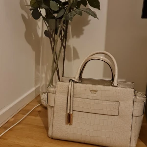 Guess damväska , Beige  - Väskan är i superbra skick utan anmärkningar eller slitage .   