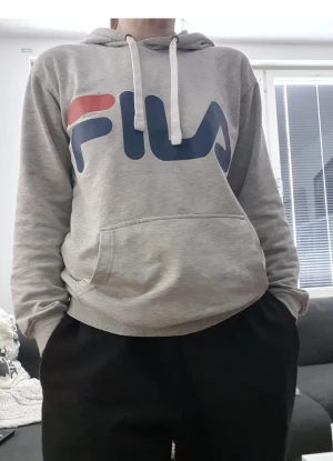FILA HOODIE CLASSIC LOGO - Stor text, unisex, oversize passform.  Gråmelerad. Fint skick! Tveka inte att skriva vid funderingar och kolla gärna mina övriga annonser för fynd.