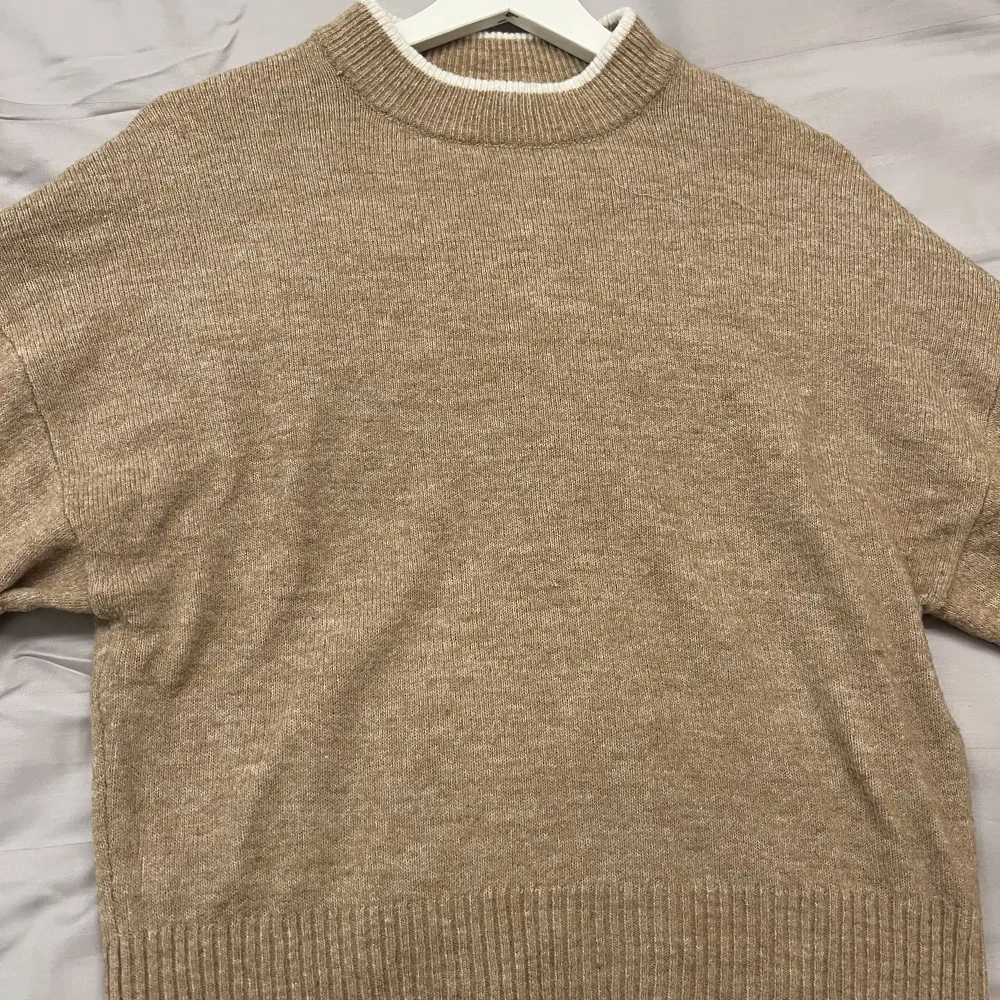 En fin stickad tröja från H&M i en ljus beige/brun färg. Tröjan är i strl XS men är väldigt stor i storleken och strechig. Köpare står för frakten. Tröjor & Koftor.