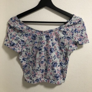 Blommig kort topp - I strl 36. Kort vid magen. Väldigt fin!