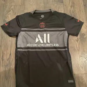 Snygg och stilren PSG tröja i färgen svart/grå och röd. Storlek S, skulle säga att den sitter mer åt M hållet.  Helt oanvänd och inget namn eller nummer på ryggen.