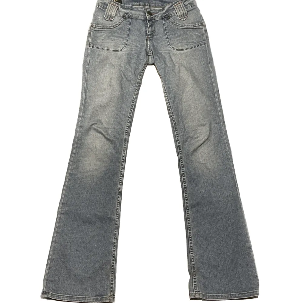 Ett par trendiga lågmidjade Lee jeans i strl W27 L35 med coola fram, och bakfickor. Välanvända och en av knapparna har ramlat av (se sista bilden). Sitter väldigt snyggt på. Midjemått tvärs över: 37cm längd: 107 cm innebenslängd: 86cm ✨möts i Stockholm✨. Jeans & Byxor.
