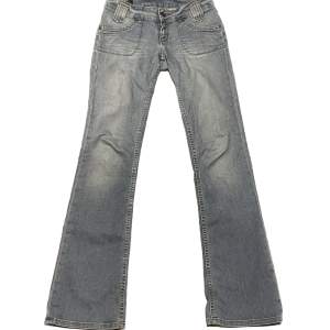 Ett par trendiga lågmidjade Lee jeans i strl W27 L35 med coola fram, och bakfickor. Välanvända och en av knapparna har ramlat av (se sista bilden). Sitter väldigt snyggt på. Midjemått tvärs över: 37cm längd: 107 cm innebenslängd: 86cm ✨möts i Stockholm✨