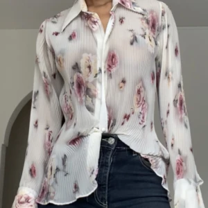 Skjorta med blomstermönster - Genomskinlig veckad långärmad skjorta. Som gjord för vår och sommar. Figurformande 