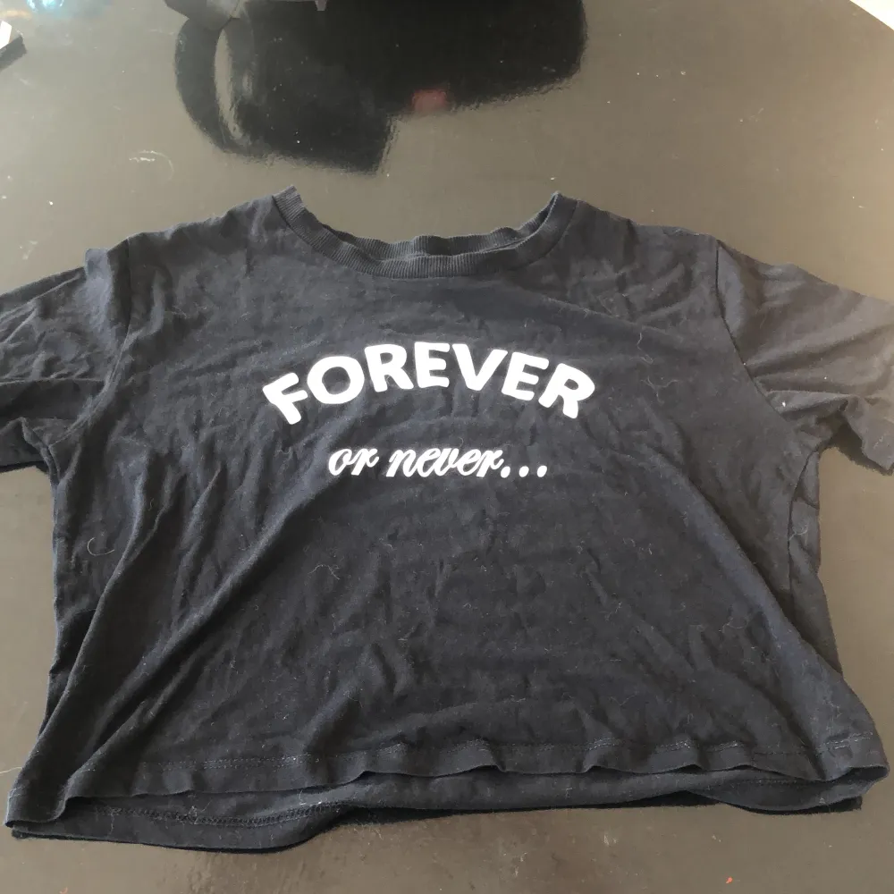 en svart croptop med texten ”forever or never” på, jättefin på men lite för kort för mig, det är xs men passar på s oxå. Toppar.