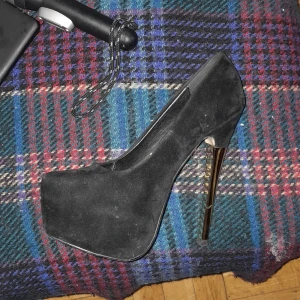 SVARTA PUMPS I SAMMET OCH MED EN 12 cm HÖG KLACK I GULDFÄRG. ALDRIG HUNNIT ATT BÄRA DEM SJÄLV DÅ DET ÄR FEL STLK FÖR MIG TYVÄRR!!SKORNA ÄR KÖPTA PÅ PAGELLE BUTIKEN I CITY. - Märkte "Truffle",stlk 37 ,inte en skråma de har legat i sin kartong under senaste 3 åren. Nypris  låg på 1600 kr men jag släpper dem för endast  800 kr prutat och klart!! Kan mötas upp i dag helst på söder men kan åka innanför tullarna om det förenklar.
