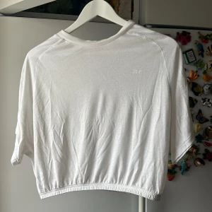 Vit croppad Reebok tröja  - Croppad vit top i bomullsmaterial från Reebok   Använd fåtal gånger men är lite nopprig runt halsen om man kollar nära 