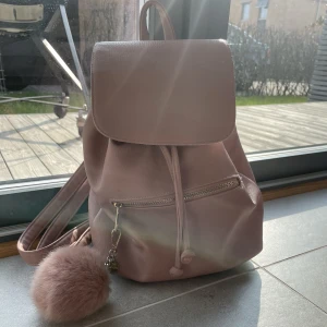 Liten ryggsäck  - Fin rosa ryggsäck från glitter knappt använd men en nyckelring på. Två fack inne och ett fack utanpå kostar 150kr frifrakt