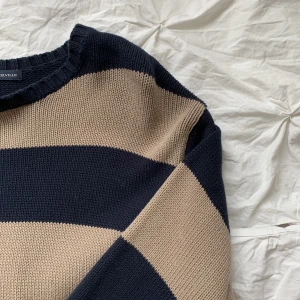 Stickad randig tröja  - En marinblå och beige randig tröja, ganska lång och varm. Nyskick🤍