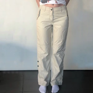 Cargo pants strl 36 - Beiga byxor I oanvänt skick med helt funktionella fickor med knappdetalj. Wide-leg fit med midjemått på 76cm och innerbenslängd på 80cm. Köparen står för frakt. Bara att dm:a vid frågor❤️