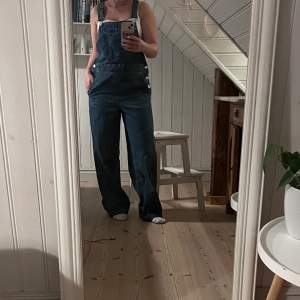 Jeans hängselbyxor från HM. Uppsydda, jag är 155 cm. Bra skick. Lite oversized. Perfekta till hösten med en stickad tröja💕hör av dig vid frågor!