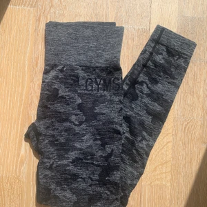Gymshark svart camo - Säljer mina snygga gymshark byxor som knappt har används då det är lite för stora för mig! De har en ”scrunch” på baksidan och är i toppen skick!