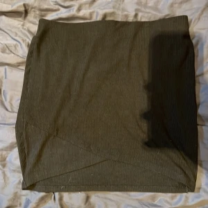 Ribbad kjol - Mycket fint skick, säljer då den inte kommer till användning.😊 Använd en gång. Strechig och bekväm. Omlottdetalj på framsidan. Passar M.