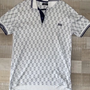 Hugo Boss pikétröja  - Säljer denna Hugo Boss pikétröjan pga utväxt, tröjan är i jättebra skick och ser helt ny ut. Använts ett fåtal gånger. Tröjan passar i storlek M/L