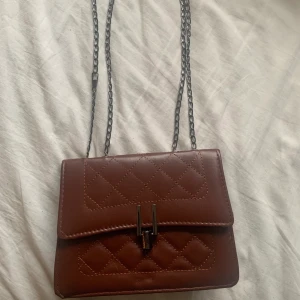 röd brun väska från secondhand - snygg röd brun väska med kedja som går at göra längre eller kortare om man vill💗