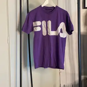 Lila T-shirt från Fila om det inte framgår genom den jättestora loggan över bröstet.