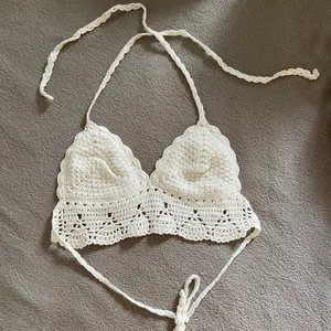 Virkad topp från SHEIN i strl M - Fin virkad somrig topp från SHEIN i färgen vaniljvit. Aldrig använd. Justerbara band som knyts bakom ryggen och runt nacken. Inte see-through så går utmärkt att använda utan bh!