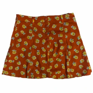 Kortkjol - Orange kortkjol med gula blommor på. Orangea knappar i fram. Tajtmodell