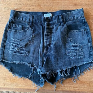Svarta slitna jeansshorts  - Svarta slitna jeansshorts. Stl. L men jag har använt dem som löst sittande shorts som har stl. S. Köpta på Nelly använda ett fåtal gånger.