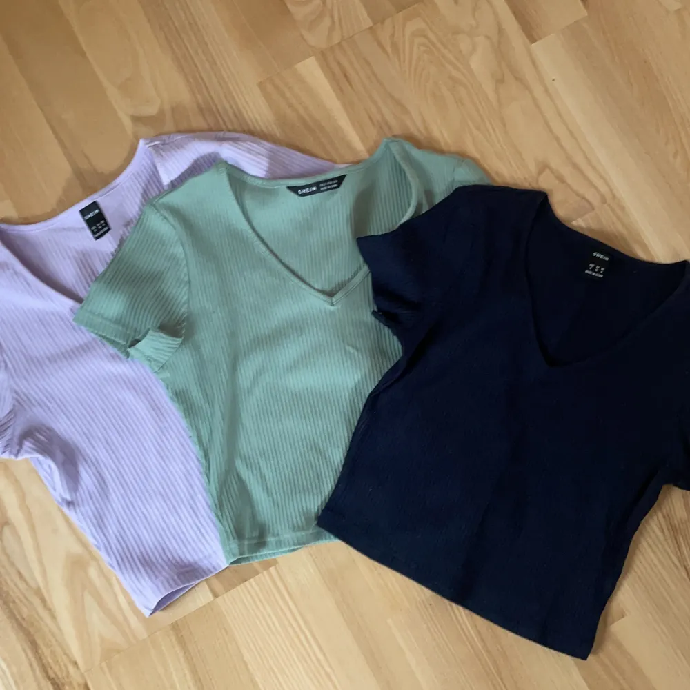 Tre vanlig cropped t-shirts, en lila, en grön och en marinblå . T-shirts.