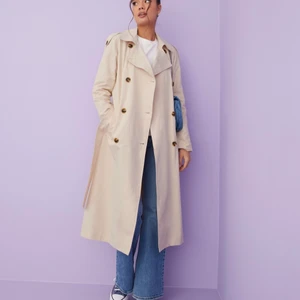 Trenchcoat från Nelly - Sandfärgad trenchcoat från Nelly. Helt ny med prislapp kvar! Säljer pga fel storlek. Nypris 999kr - mitt pris: 550kr. Storlek 42! Köparen står för frakt 😇 