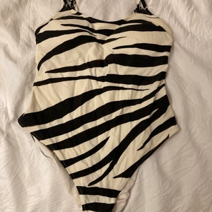 Zebramönstrad baddräkt, storlek XS - Ganska liten över bysten men annars sitter som den ska. Högmidjad och blir låg i ryggen när den sitter på, inläggen är uttagbara om önskas och banden är justerbara. Köpt för 2 år sedan och använd bara ett fåtal gånger. ☀️ Frakt ingår inte☀️                             