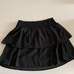 Svart volangkjol - Säljer denna helt oanvända volangkjolen i superfint material då den är lite för stor för mig. Den är i storlek xs men skulle säga att den passar upp till m/l också då den är så stretchig. Pris kan diskuteras. Köparen står för frakt. Skriv privat för fler bilder!