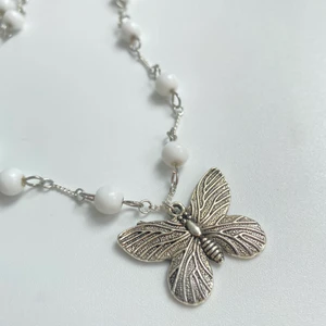 Halsband med fjärilsberlock - Halsband med kedja och vita pärlor och en fjärilsberlock. Nickelfritt och silverpläterat🤍