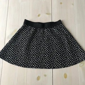 Söt prickig barnkjol - Svart kjol med vita prickar, resår i midjan. Inte använd många gånger.  Längd: Ca 35 cm Köparen står för frakten!