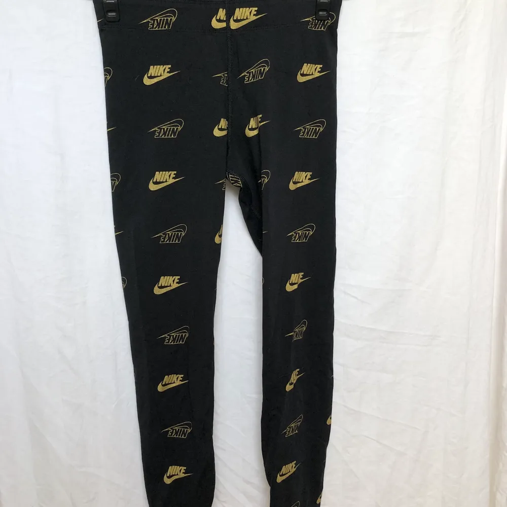 Svarta Nike leggings med guld loggor. Aldrig använda.. Jeans & Byxor.