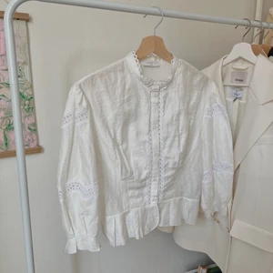 vit blus från sandro - Superfin blus från Sandro, med spetsdetaljer, volanger och bra passform! Använt endast 1 gång då jag fick den i födelsedagspresent men inte riktigt min smak! Size S men tycker den passar XS och M utmärkt. Nypris 2395kr.