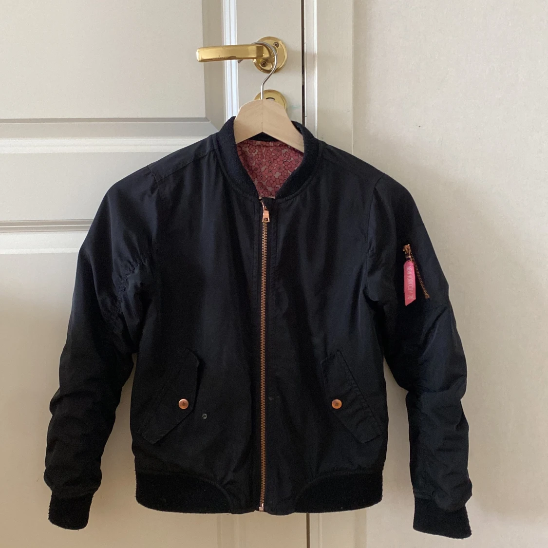 Svart jaka med blommigt innertyg 