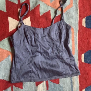 Siden topp - Topp i sidenliknande tyg. Stretchig och figursydd. Täcker precis naveln på mig. Dragkedja på baksidan. Som ny med en omgång strykjärn.