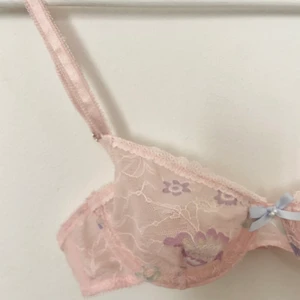 Blommig spets-BH 32B - En jättefin blommig spets-BH köpt på Urban Outfitters i London. Storleken är 32B men det är mer som en A-kupa. Liten i storleken. Nyskick och ej använd då den tyvärr är för liten för mig. 