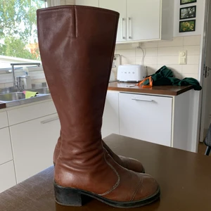 Stövlar  - Höga bruna stövlar, ganska smala i skaftet 