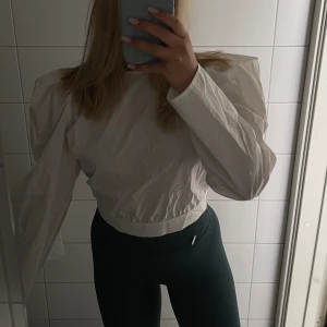 Vit blus/topp - Vit blus eller topp med höga axlar och öppen i ryggen! Aldrig använd!🤍 Storlek S