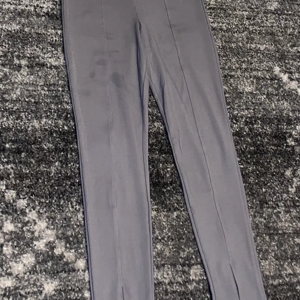Ett par gråa leggings som är utsvängda ner till. Finns tecken på användning då fläckar finns på benen. 20kr + 52kr frakt. Jeans & Byxor.