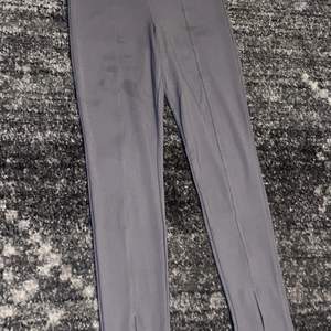 Ett par gråa leggings som är utsvängda ner till. Finns tecken på användning då fläckar finns på benen. 20kr + 52kr frakt