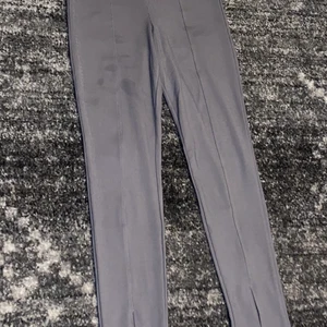 Utsvängda leggings  - Ett par gråa leggings som är utsvängda ner till. Finns tecken på användning då fläckar finns på benen. 20kr + 52kr frakt
