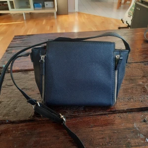 Svart väska  - Snygg liten svart väska med guld kedja. 