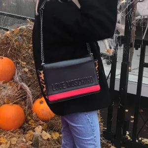 Moschino väska - Säljer denna coola moschino väska då jag inte använder den längre. Får plats med mycket i den! Köpt för 3000kr på Zalando säljer för 600kr