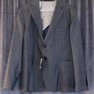 Oscar Jacobson Kostym (Diego) - Helt ny Kostym från Oscar Jacobson med prislapp på, i toppkvalité! Nypris 5500 set (kostym/kavaj + kostymbyxor). Aldrig använd. Mörkgrå! Priset är för hela kostymsetet, men kan säljas separat om så önskas!