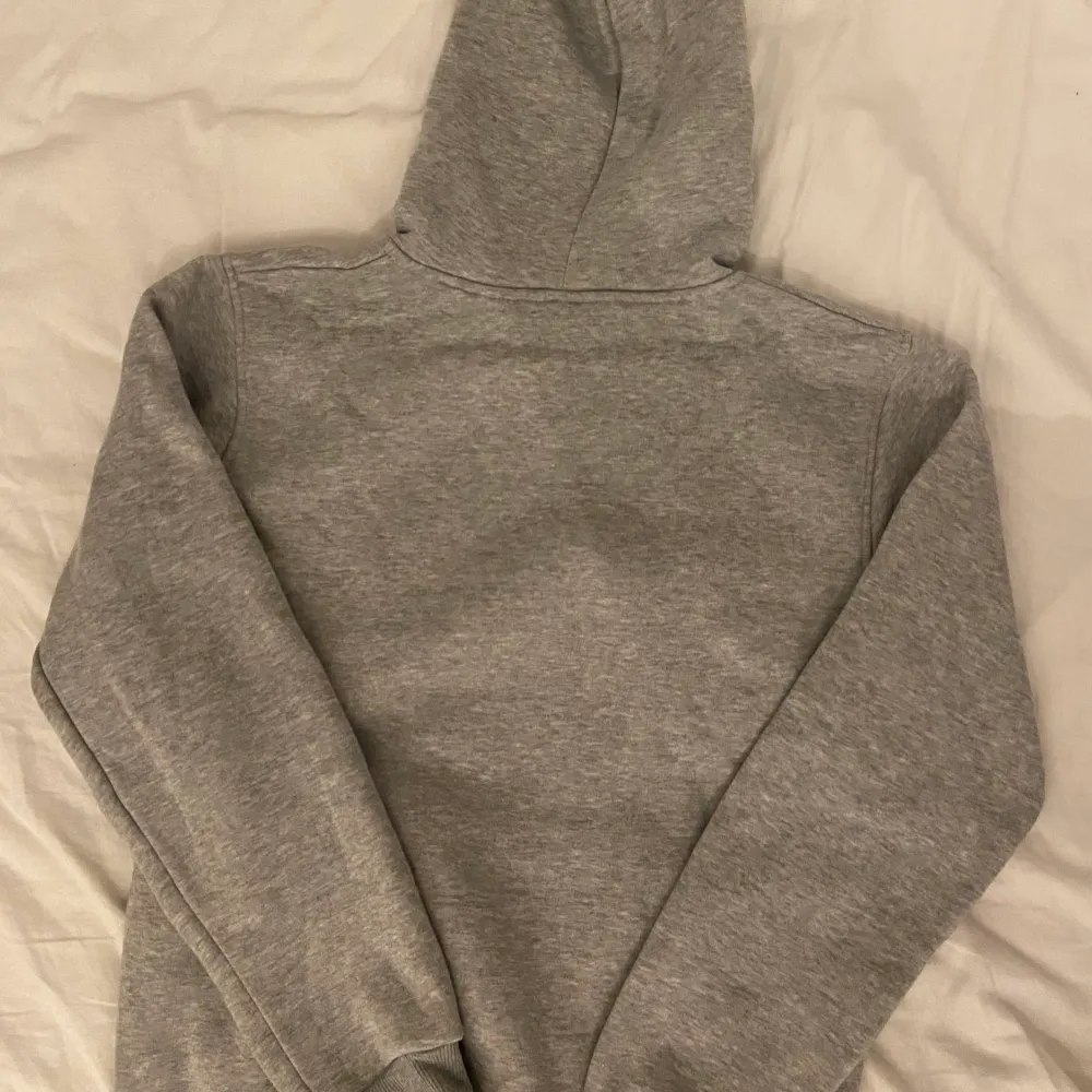 Säljer en grå Thrasher hoodie, perfekt för streetwear och skater-stil. . Hoodies.
